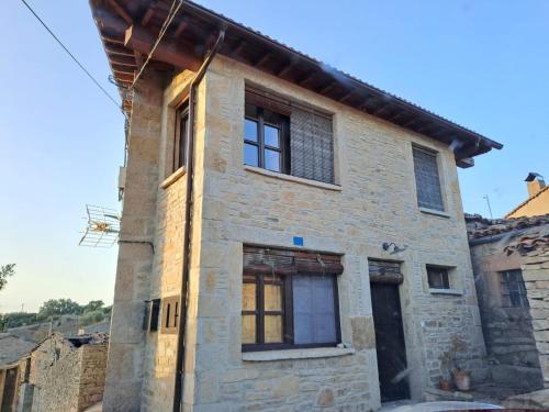 a stone house with two windows on the side at GEODA Fornillos -Refugio en los Arribes del Duero in Fornillos de Fermoselle