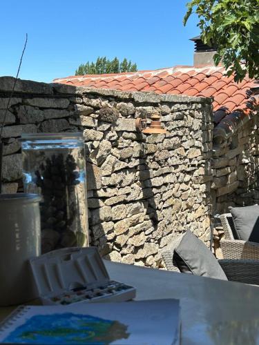 a stone wall with a table in front of it at GEODA Fornillos -Refugio en los Arribes del Duero in Fornillos de Fermoselle