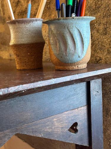 two vases sitting on top of a wooden table at GEODA Fornillos -Refugio en los Arribes del Duero in Fornillos de Fermoselle
