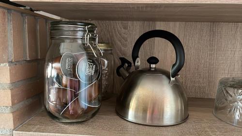 a tea kettle and a jar on a shelf at GEODA Fornillos -Refugio en los Arribes del Duero in Fornillos de Fermoselle