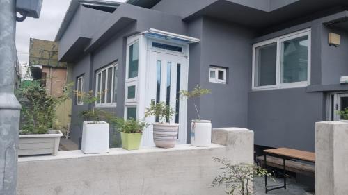 a house with potted plants on the front porch at Happy Stay in Gyeongju
