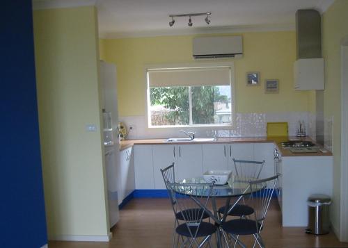 uma cozinha com uma mesa e cadeiras e um lavatório em Lindsays of Kangaroo Island em Penneshaw