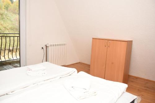 a room with two beds and a wooden cabinet at Vikendica Čeperković #1 in Kopaonik