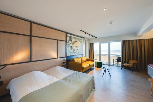 a hotel room with a bed and a living room at Vayamundo Oostende in Ostend