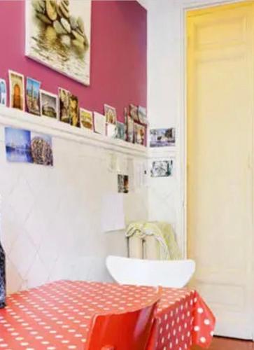 une salle à manger avec une table et un mur rouge dans l'établissement Chambre quartier Longchamp, à Marseille