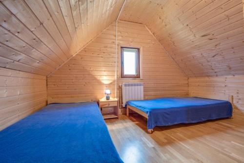 ポランチクにあるChatka Zuziaの木造キャビン内のベッドルーム1室(ベッド2台付)