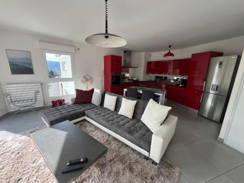 un salon avec un canapé et une cuisine dans l'établissement Appartement standing vue lac, à Annecy