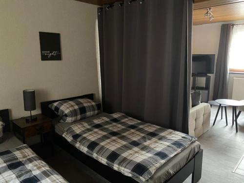 a bedroom with two beds and a table and a window at Ferienwohnung Fürst in Ehringshausen