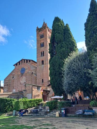 a large brick building with a tower in a park at Hotel Minerva in Siena