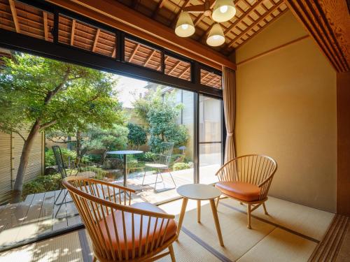 a room with two chairs and a table and a large window at Sekitaitei Ishida in Achi