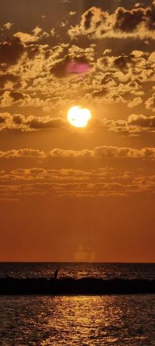 a sunset over the ocean with the sun in the sky at Luxury Beach House in Bari