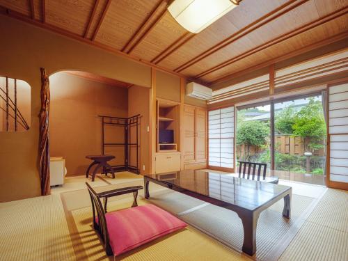 a living room with a table and a large window at Sekitaitei Ishida in Achi