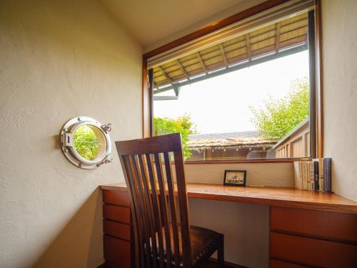 a chair sitting in front of a window with a mirror at Sekitaitei Ishida in Achi