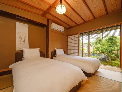 two beds in a room with a window at Sekitaitei Ishida in Achi