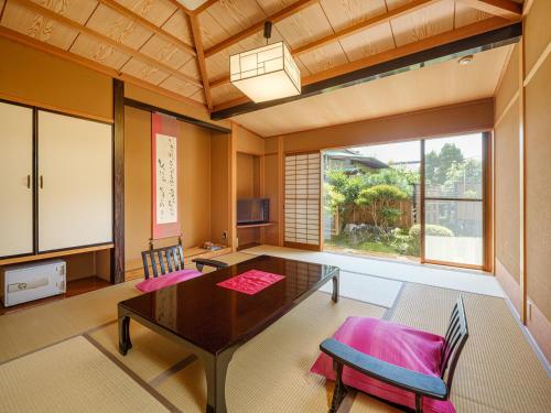 a living room with a table and a large window at Sekitaitei Ishida in Achi