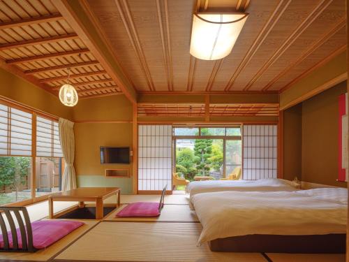 a bedroom with two beds and a large window at Sekitaitei Ishida in Achi