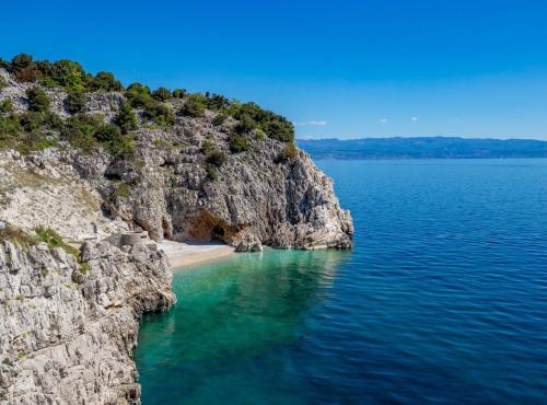 a view of a beach on a rocky cliff at Chic and Cozy Brsec Apartment with Sea View in Brseč