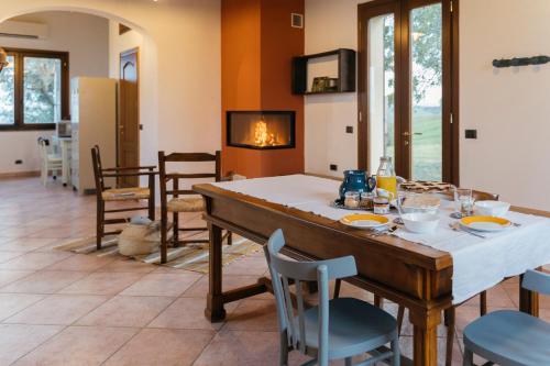 a dining room with a table and chairs and a fireplace at Casa Schiavoni in Forlì