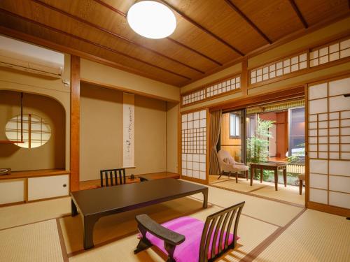 a japanese room with a table and chairs at Sekitaitei Ishida in Achi