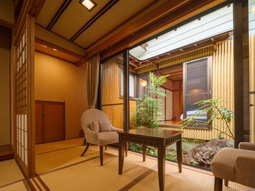 a room with a table and a chair and a window at Sekitaitei Ishida in Achi