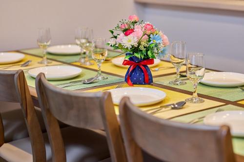 a table with glasses and a vase of flowers on it at APROStay富士河口湖小立9 in Fujikawaguchiko