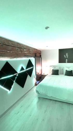 - une chambre avec un lit blanc et un mur orné d'une peinture dans l'établissement L'Ambitieux - Centre de Vienne, à Vienne