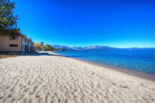 a beach with sand and water and mountains in the background at Sky Lake Splendor condo in South Lake Tahoe