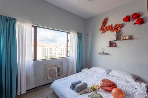 a bedroom with a bed and a window with a love sign at Viors Staycation in Cainta