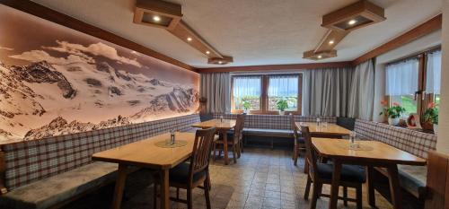 a restaurant with wooden tables and chairs in a room at Gasthof Pension Santeler in Sankt Leonhard im Pitztal