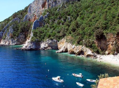 a group of boats in the water next to a mountain at Chic and Cozy Brsec Apartment with Sea View in Brseč