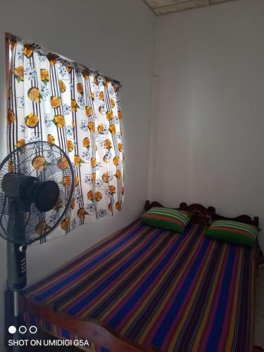 a bedroom with a bed with a curtain and a crib at Wasana Guest Yala in Kirinda
