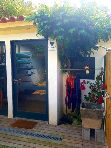 a door to a house with a tree next to it at Conde Surf Camp - Capsule Beds MIXED Dorm in Vila do Conde