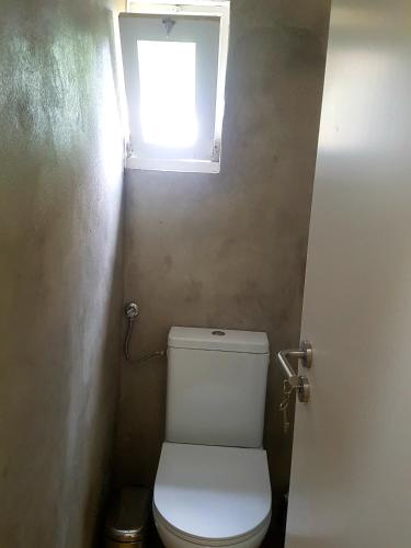 a small bathroom with a toilet with a window at Conde Surf Camp - Capsule Beds MIXED Dorm in Vila do Conde