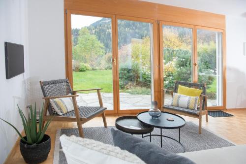 a living room with a couch and chairs and a window at Ferienunterkunft Furnerschhus für 4 Personen in Churwalden in Churwalden
