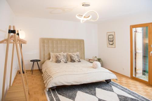 a white bedroom with a large bed with a tripod at Ferienunterkunft Furnerschhus für 4 Personen in Churwalden in Churwalden