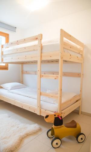 a wooden bunk bed with a wooden toy car in a room at Ferienunterkunft Furnerschhus für 4 Personen in Churwalden in Churwalden