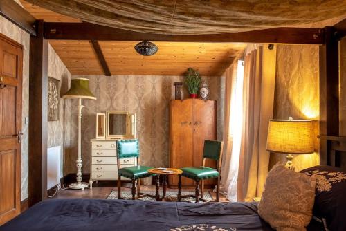 a bedroom with a bed and two chairs and a table at Wild Oats 14 Yellowtop Country Park in Foggathorpe
