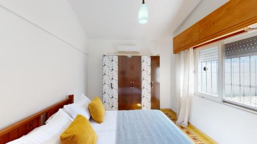 a bedroom with a bed with yellow pillows and a window at Casa chalet , Centro de La Paloma in La Paloma