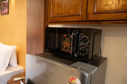 a microwave sitting on top of a refrigerator at Vistar Holidays in Goa