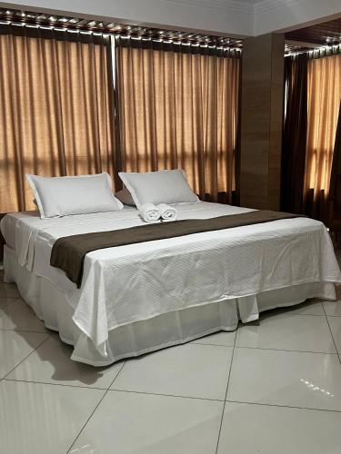 a large bed with two towels on top of it at Brisas do Mar HOTEL & APART in Valença