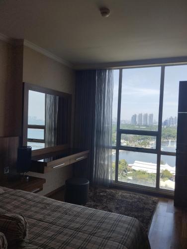 a hotel room with a bed and a large window at Ancol Mansion Apartment Sea View by Berlin Village in Jakarta