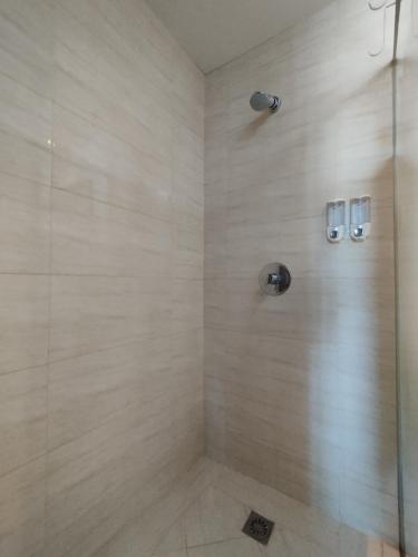 a bathroom with a shower with a glass door at Ancol Mansion Apartment Sea View by Berlin Village in Jakarta