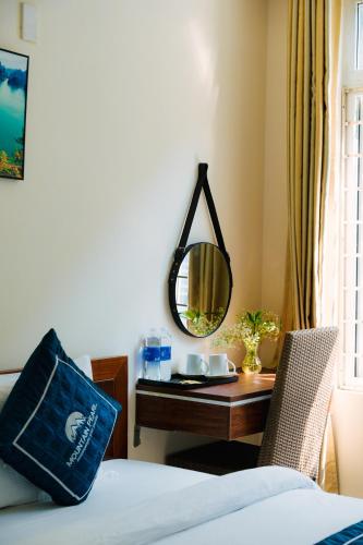 a bedroom with a bed and a desk with a mirror at Catba Cannon Fort Hotel & Spa in Cat Ba