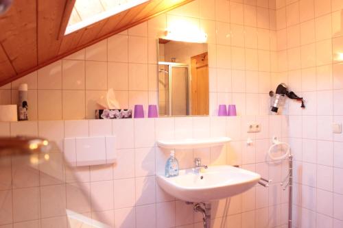 W białej łazience znajduje się umywalka i lustro. w obiekcie Familienferienhof Kroner w mieście Zwiesel