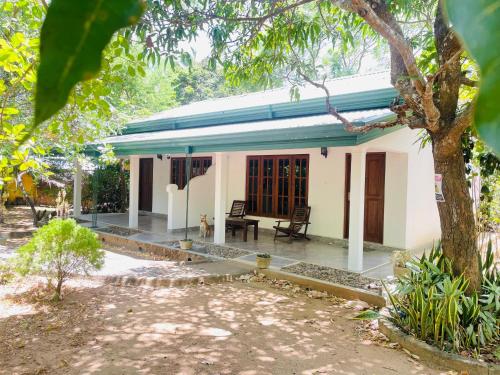 a small white house with a tree in front of it at Tamarind Tamarind Resort, Tourist Board Approved in Habarana
