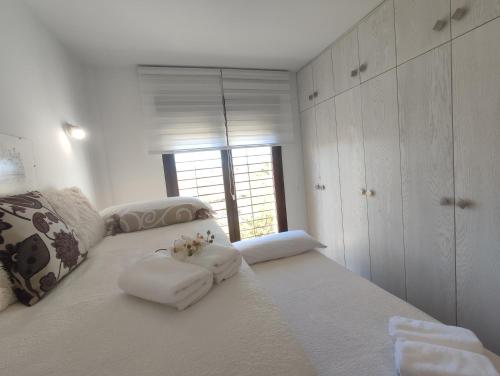a bedroom with a large white bed with towels on it at Casa El Nacimiento in Guadix