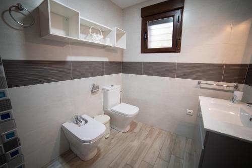 a bathroom with a toilet and a sink at Casa El Nacimiento in Guadix