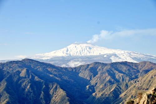 a mountain with snow on top of it at Vista Alcantara - Wellness Mountain-Top Retreat in Motta Camastra