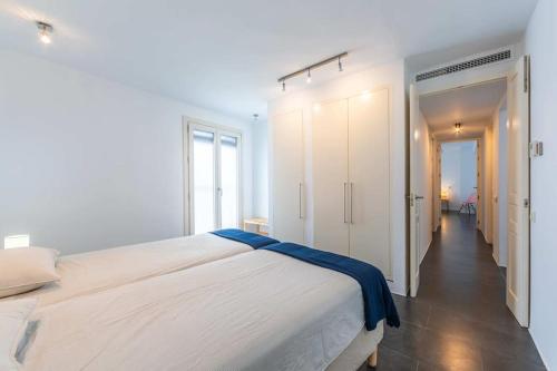 - une chambre blanche avec un grand lit et un couloir dans l'établissement Estanco Azul Home Ideal families or nomads Speed Wifi Spacious Located in Center, à Tarifa