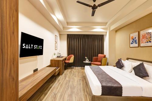a hotel room with a bed and a desk at Saltstayz Premier - Golf Course Road & Sector 42 in Gurgaon